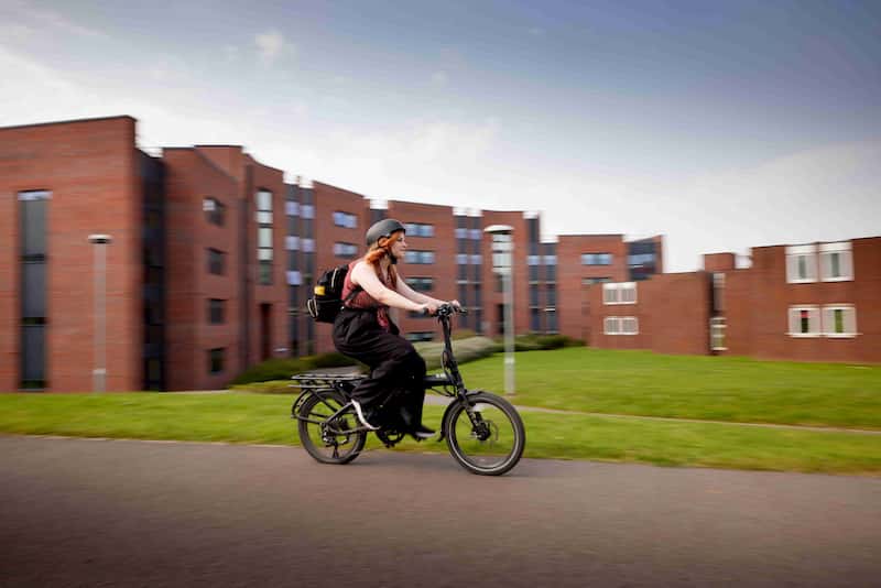Student riding bike on campus